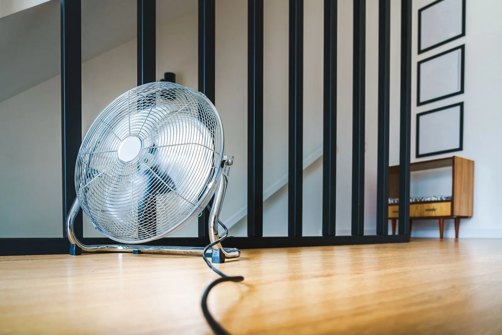 A fan drying a wooden floor in a quiet room